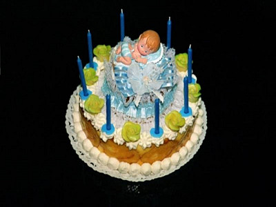 Mandarinensahnetorte mit Baby und Kerzen